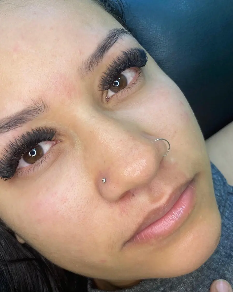 Close da cliente destacando a extensão de cílios volumosa e bem definida
