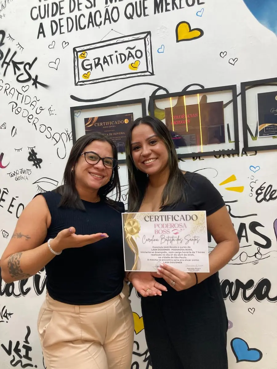 Gabriella ao lado de aluna certificada exibindo diploma do curso