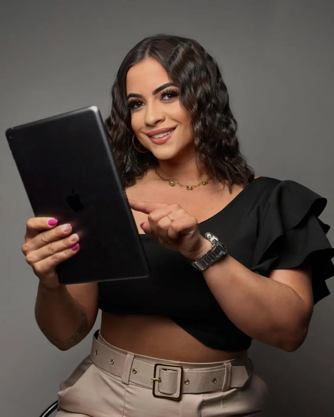 Gabriella, especialista em extensão de cílios, atendendo com tablet em mãos